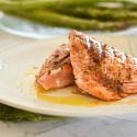Grilled salmon with a Cajun spice rub on a plate with asparagus and salad./