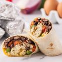 Freeezer breakfast burritos with eggs, peppers, black beans, and cheese wrapped in a tortilla.