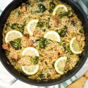 Lemon orzo cooked with chicken sausage and broccoli in a skillet.