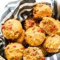 Savory feta cheese muffins with red peppers and feta crumbles served in a basket.