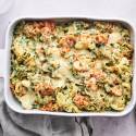 Spinach artichoke pasta with melted cheese in a casserole dish.