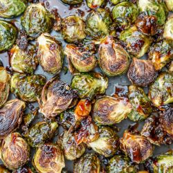 Crispy Asian Brussel sprouts on a baking sheet with soy sauce and honey glaze.