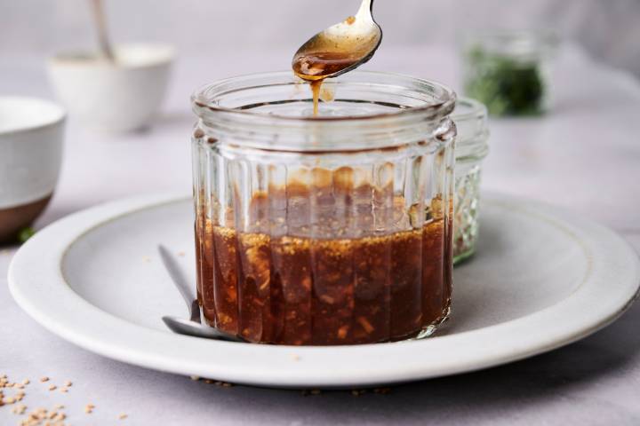 Homemade teriyaki sauce in a jar with a spoon.