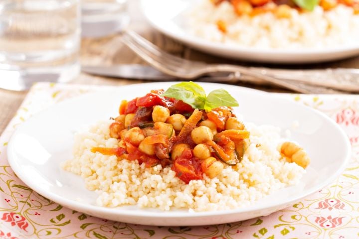 Mediterranean chickpeas in a bowl with tomatoes, fresh herbs, and garlic. 
