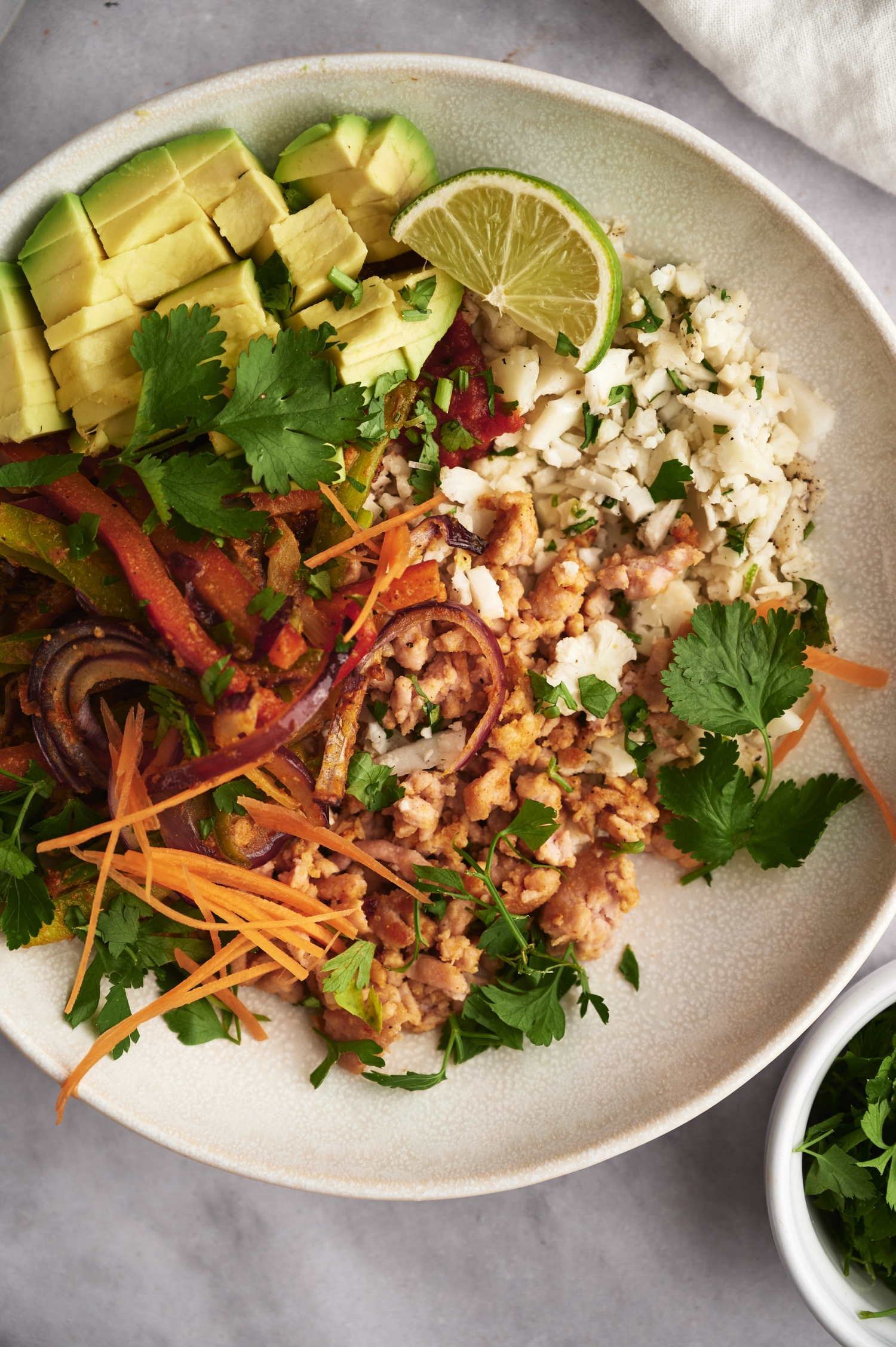 Low carb taco bowls with cilantro lime cauliflower rice, ground turkey, and avocado.