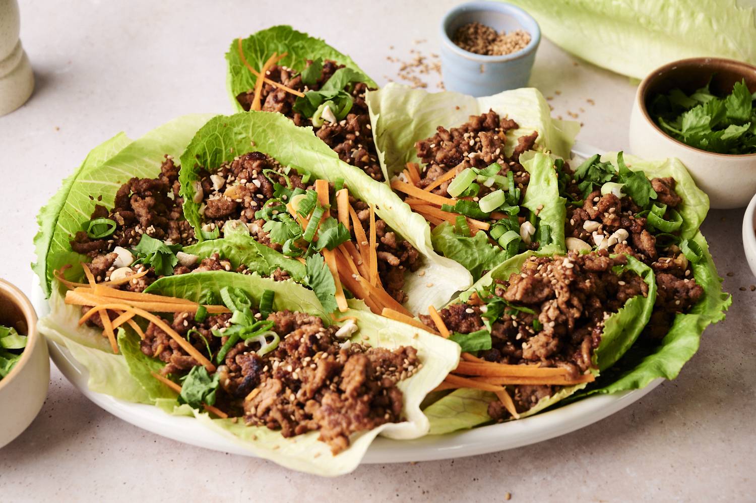 A plate of Korean beef lettuce wraps with chopsticks.