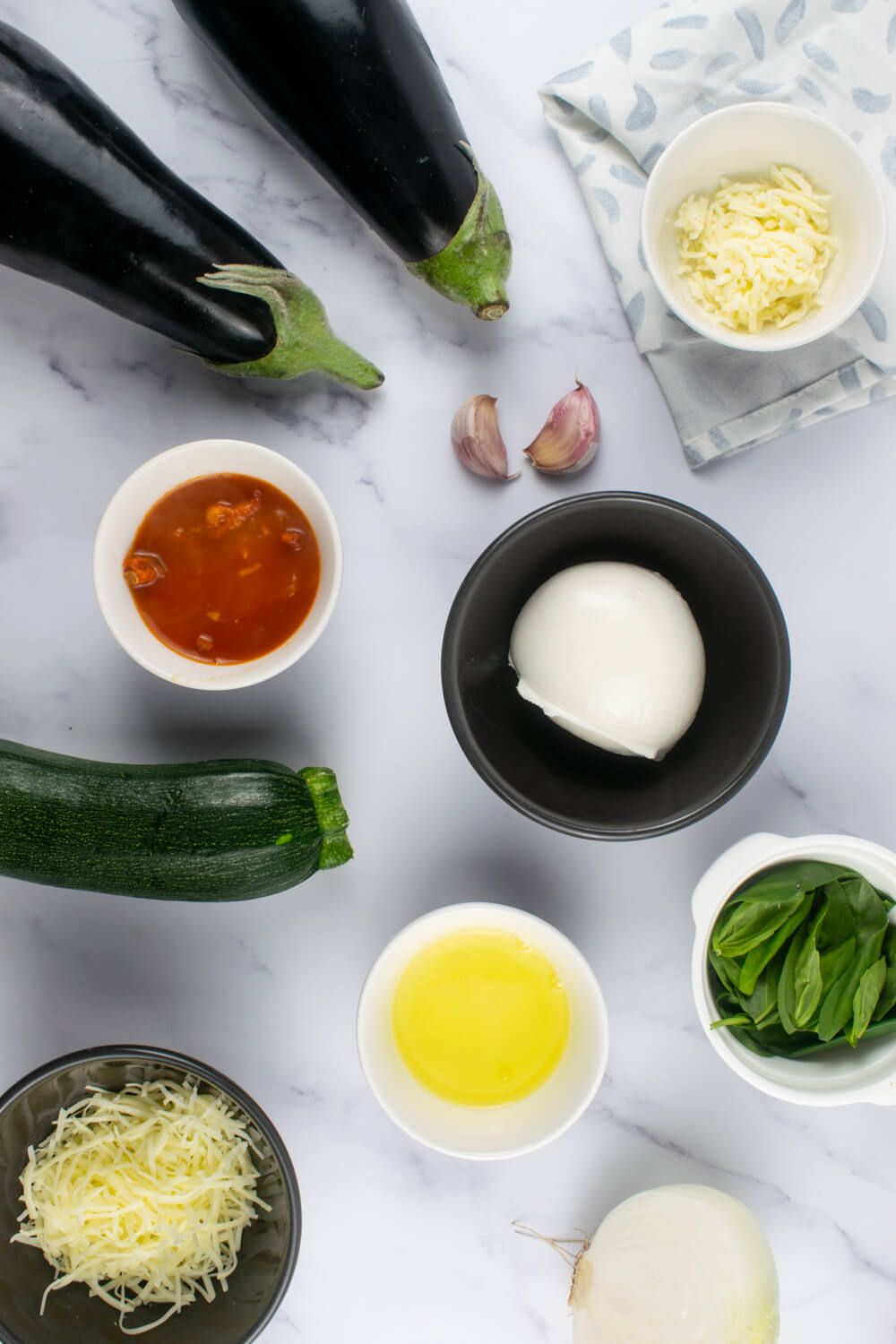 Ingredients for eggplant rollatini on a marble counter.