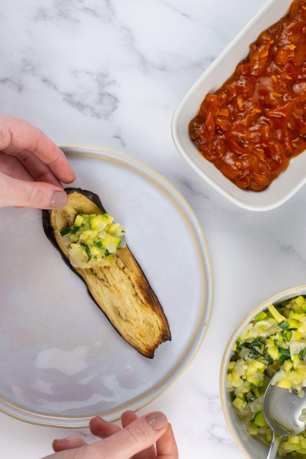 Eggplant rollatini being stuffed with zucchini and cheese.