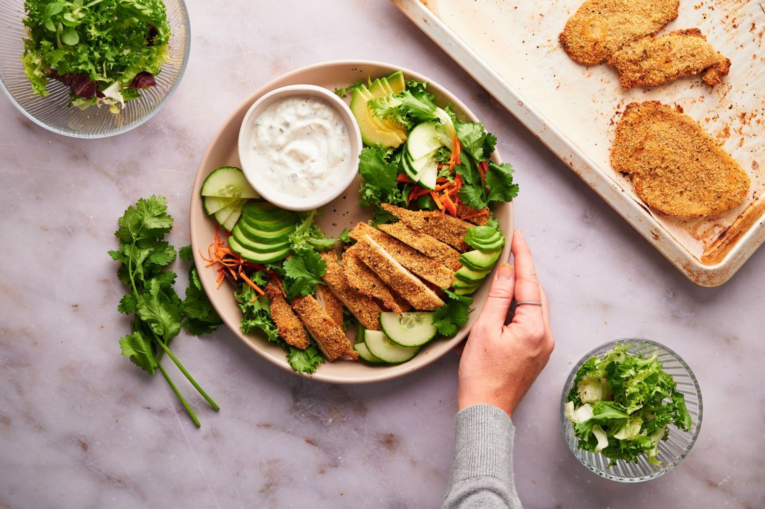 Chicken cutlets served with salad and dipping sauce on a plate. 