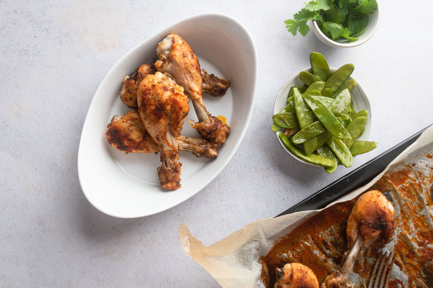 Oven baked drumsticks with tender chicken coated in spices and served with sautéed snow peas.