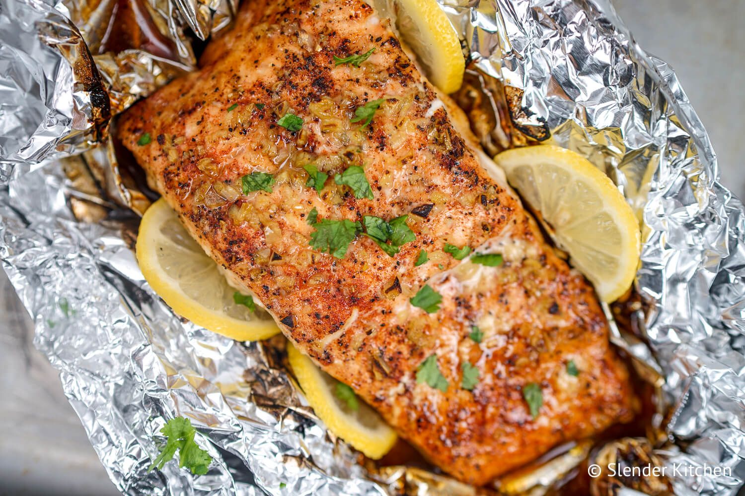 Baked Garlic lemon salmon wrapped in foil with lemons.