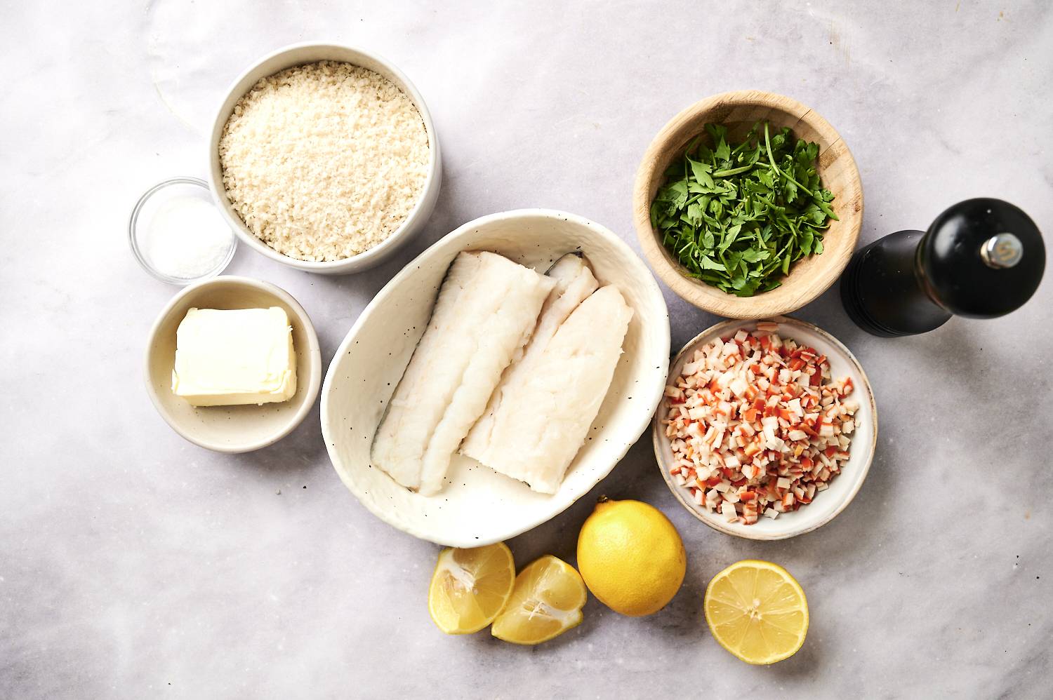 Ingredients for baked stuffed haddock including breadcrumbs, butter, crab, lemon, and parsley.