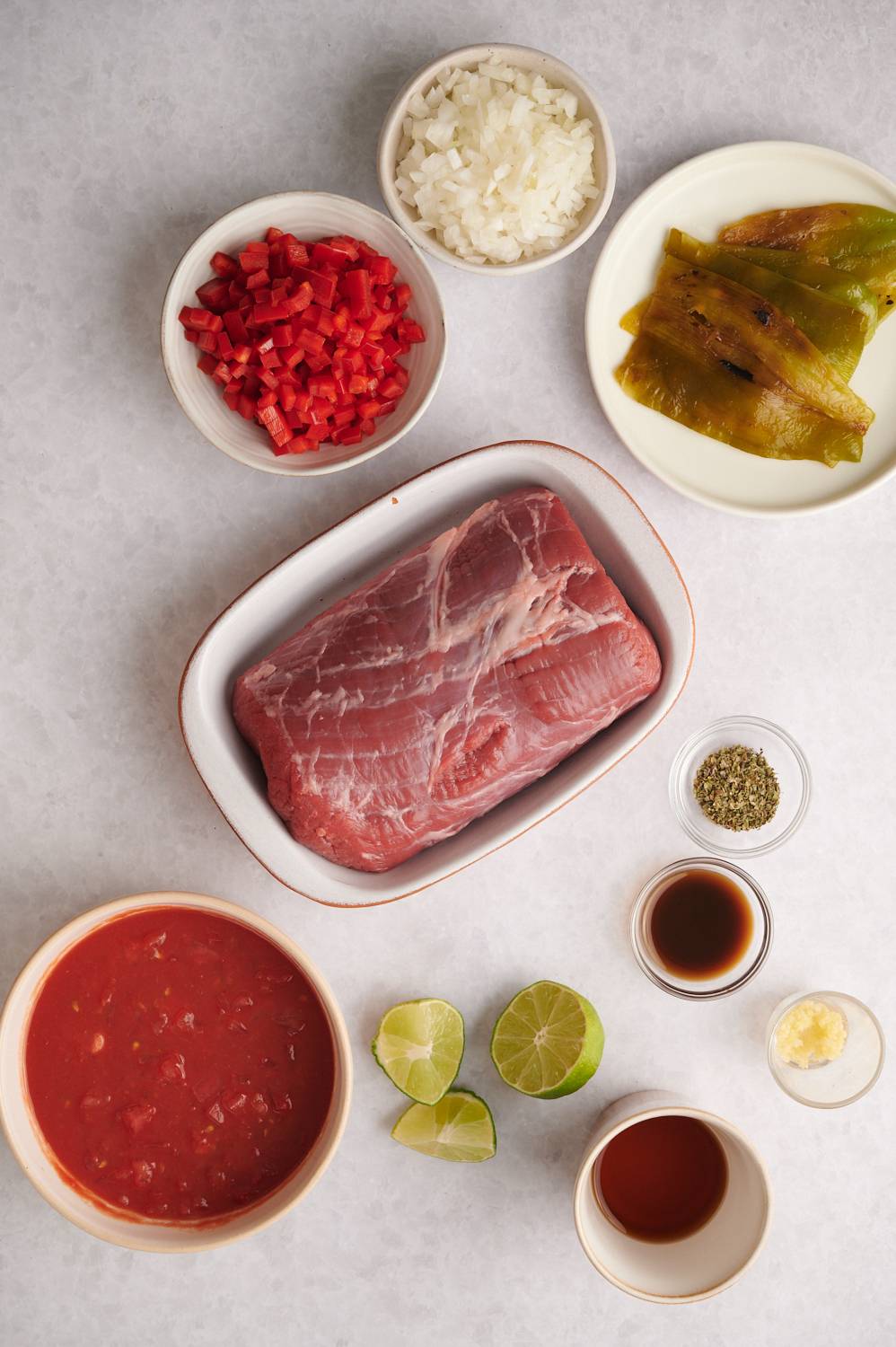 Ingredients to make beef machaca including beef, tomatoes, peppers, onions, garlic, chile peppers, and spices.