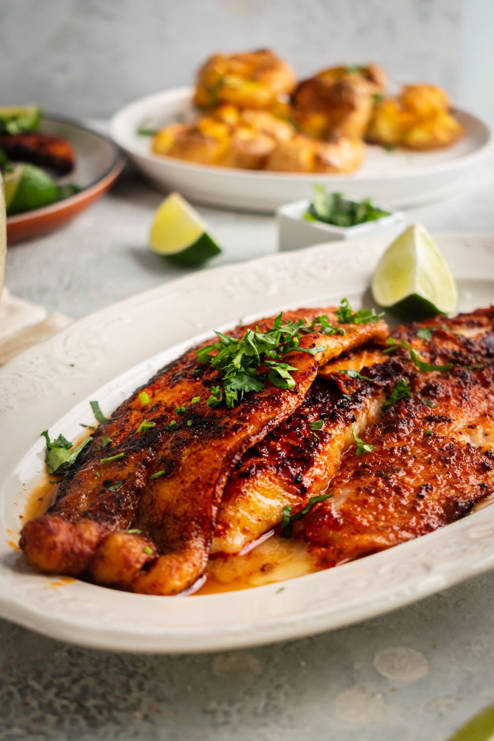 Mahi Mahi cooked with blackening seasoning and served with parsley, limes, and potatoes.