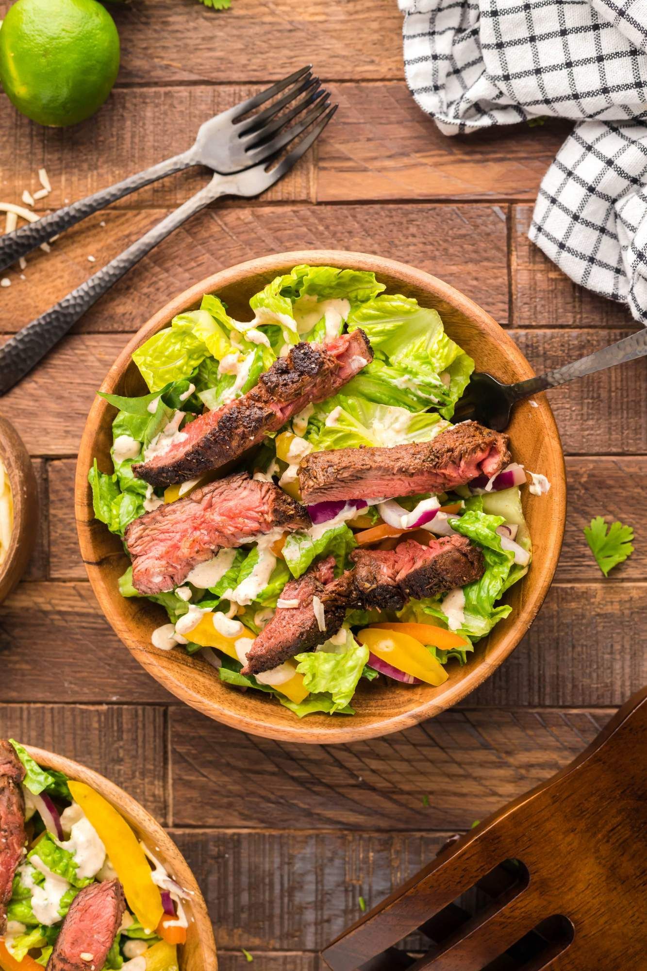 Spicy homemade steak salad with blackened steak served over lettuce, peppers, cheese, reed onion, and a creamy southwest dressing.