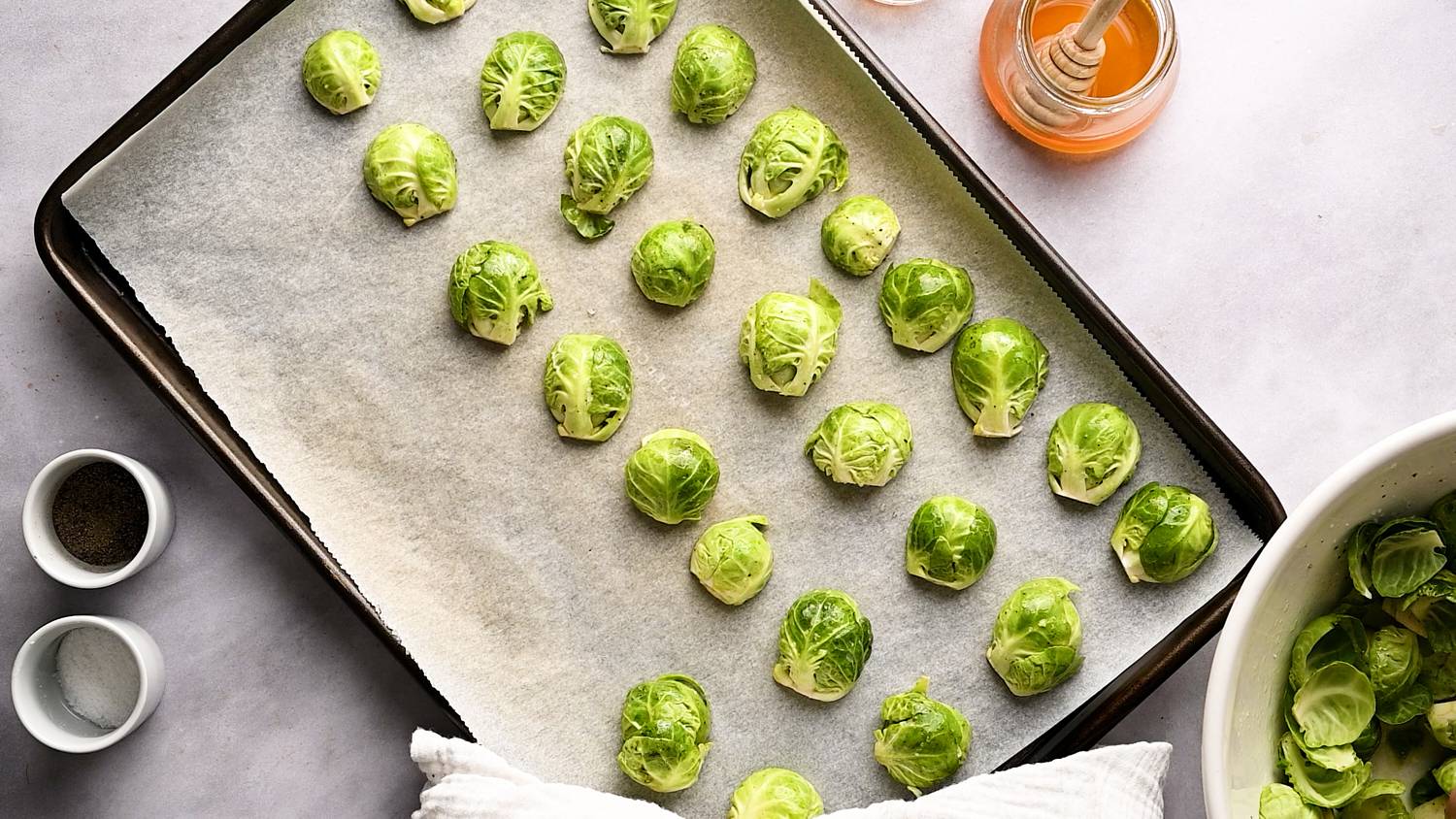 Brussels sprouts cut in half in a single layer on a baking sheet.