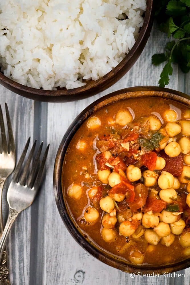 Chana Masala recipe in a wooden bowl with cilantro and white rice.