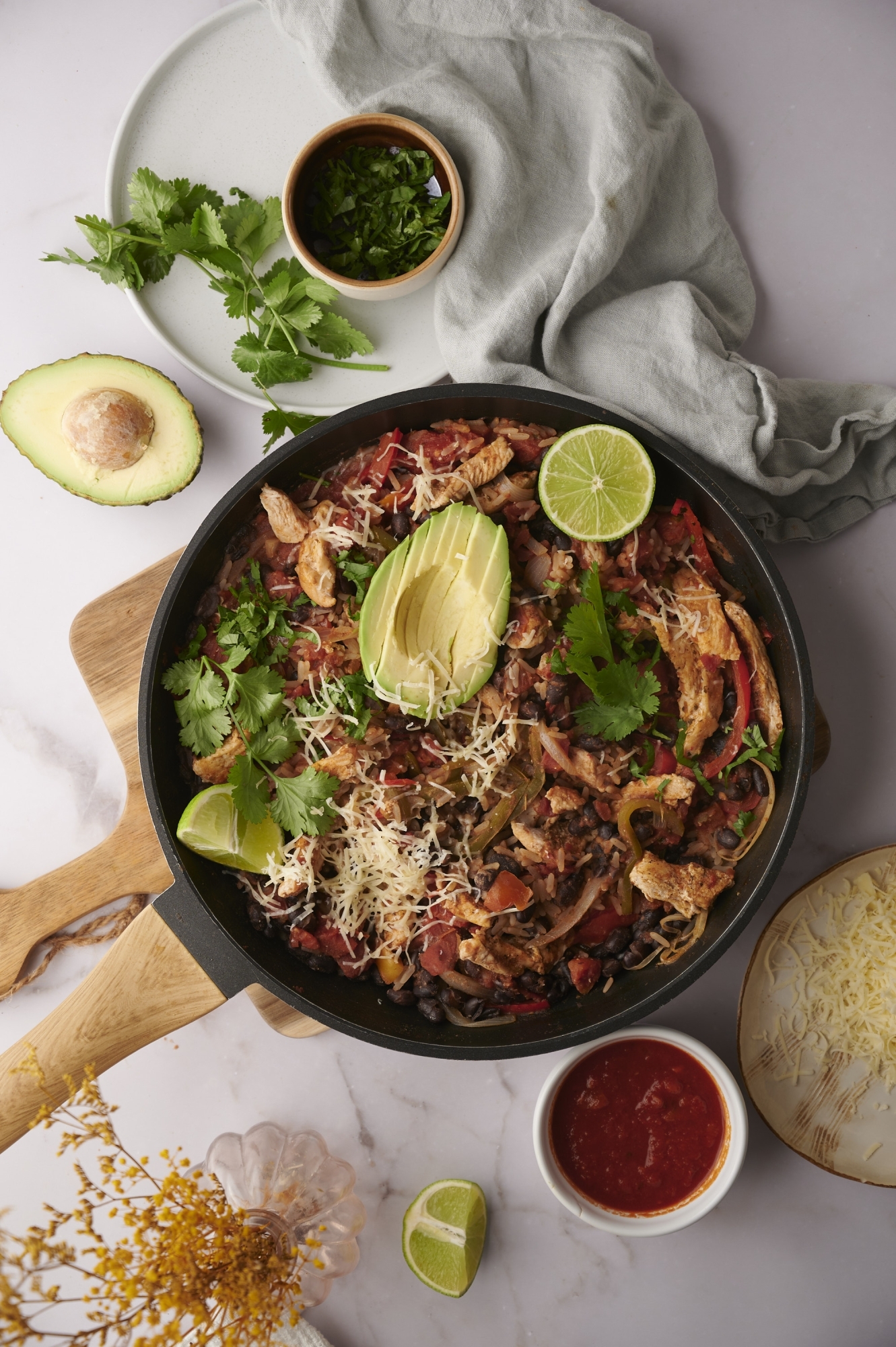One pot chicken and rice with chicken breast, rice, peppers, beans, avocado, and cheese.