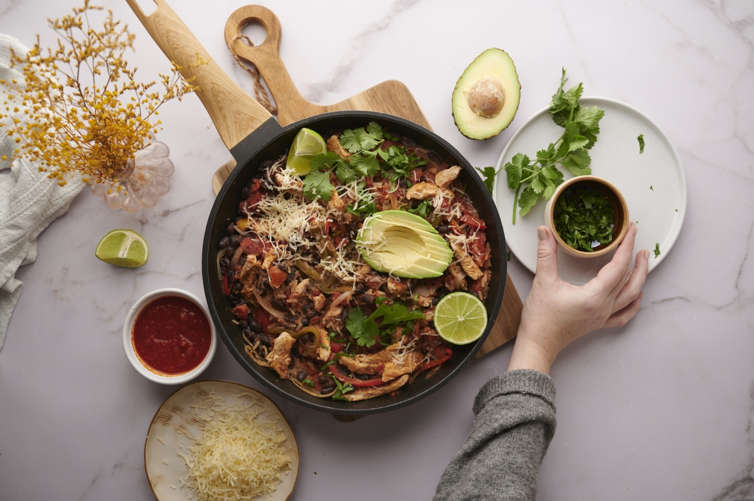 Mexican rice and chicken with bell peppers, onions, black beans, and rice in a skillet.