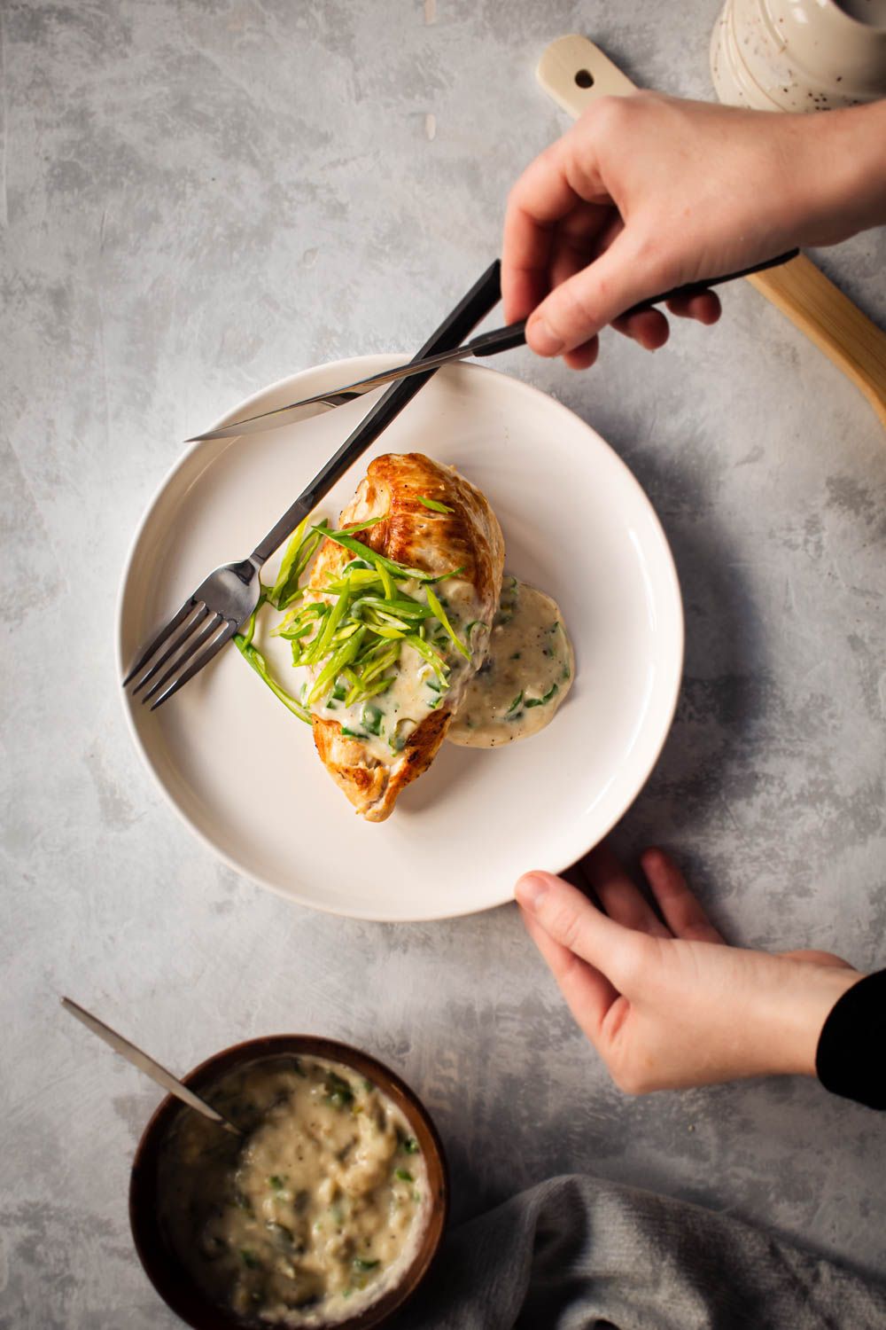 Jalapeno chicken breast with a creamy and spicy sauce on a plate a hand holding the plate.