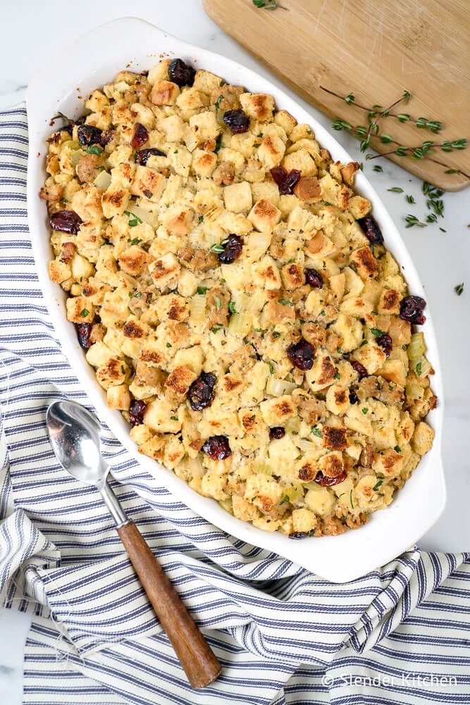 Cornbread stuffing with chicken sausage and cranberries in a dish with thyme.