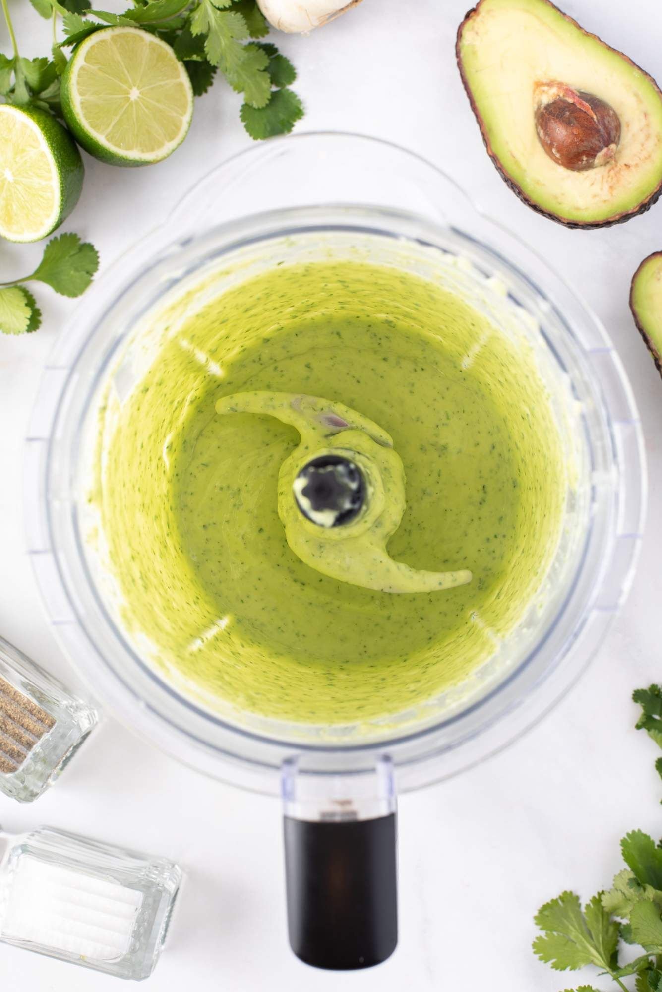 A food processor with avocado dressing with cilantro, yogurt, and lime juice.