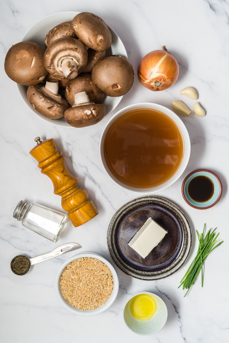 Ingredients for one pot mushroom rice including bella mushrooms, vegetable broth, brown rice, cream cheese, and garlic.