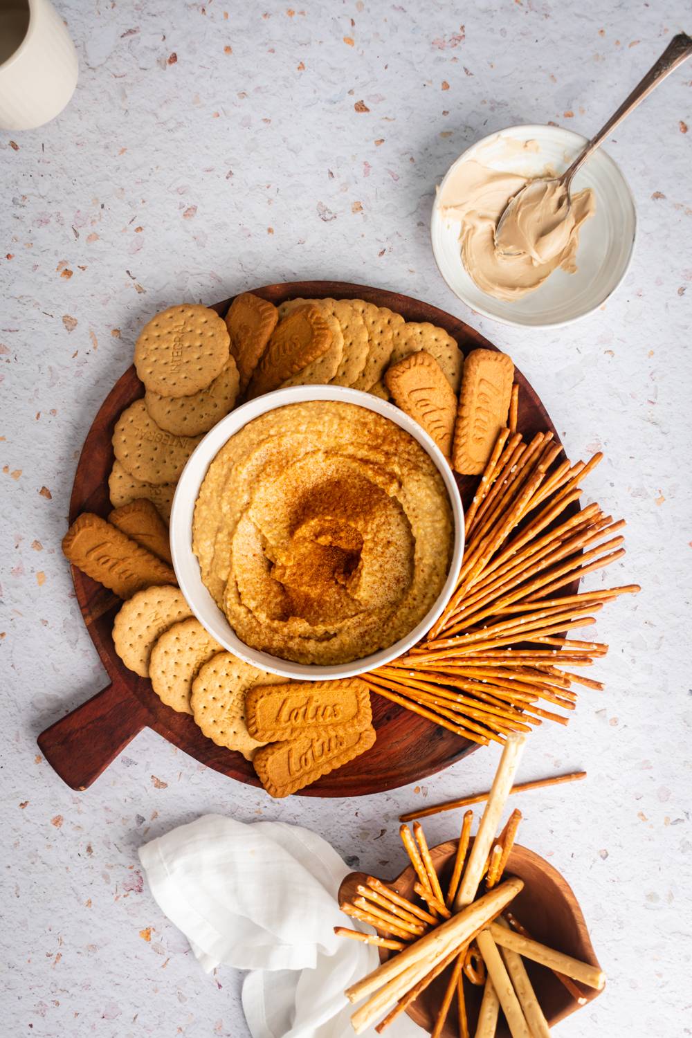 Cinnamon dessert hummus made with chickpeas served in a bowl with cookies, graham crackers, and pretzels.