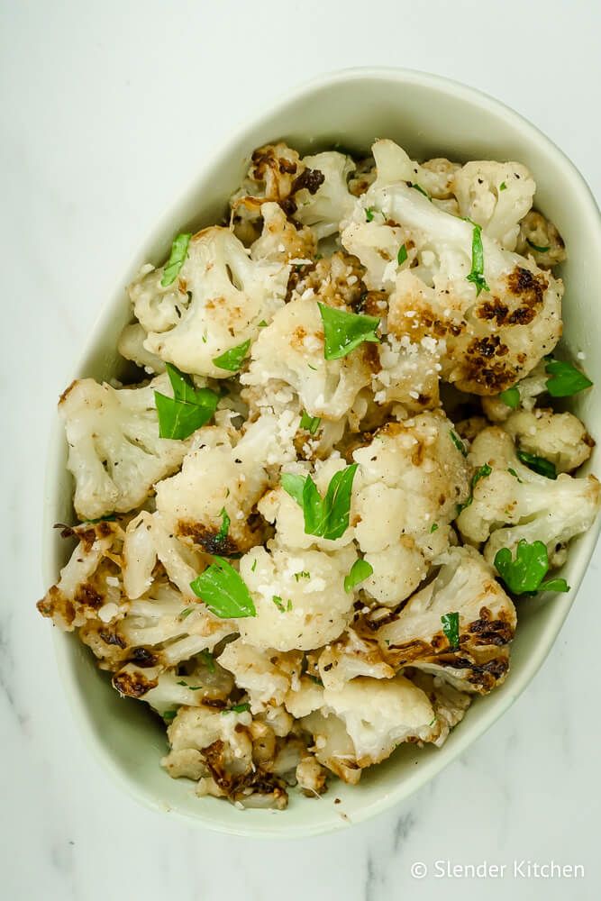 Roasted cauliflower with Parmesan, lemon, and parsley in a light blue dish.