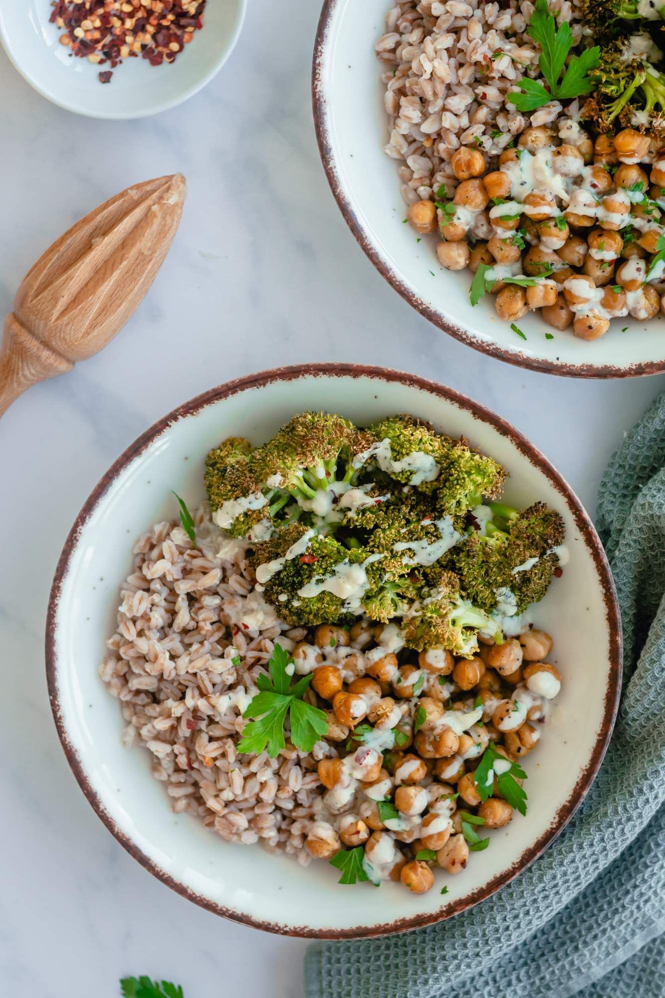 Farro broccoli bowls with chickpeas and cooked farro in a bowl with garlic tahini sauce.