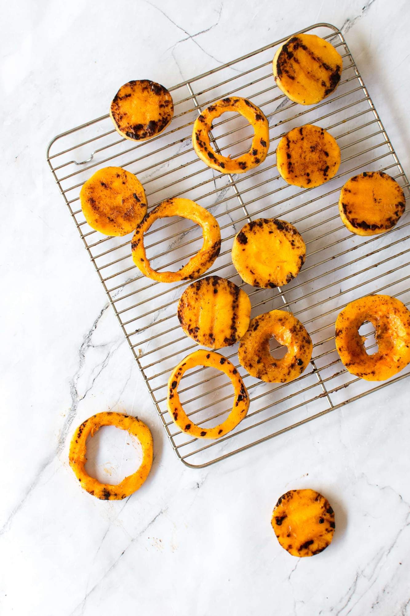 Grilled squash on a wire rack with grill marks and a homemade spice blend.