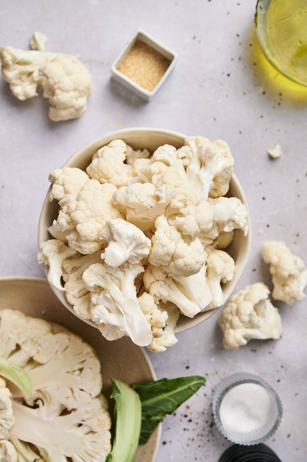 Ingredients for grilled cauliflower including cauliflower florets, olive oil, salt, and pepper.