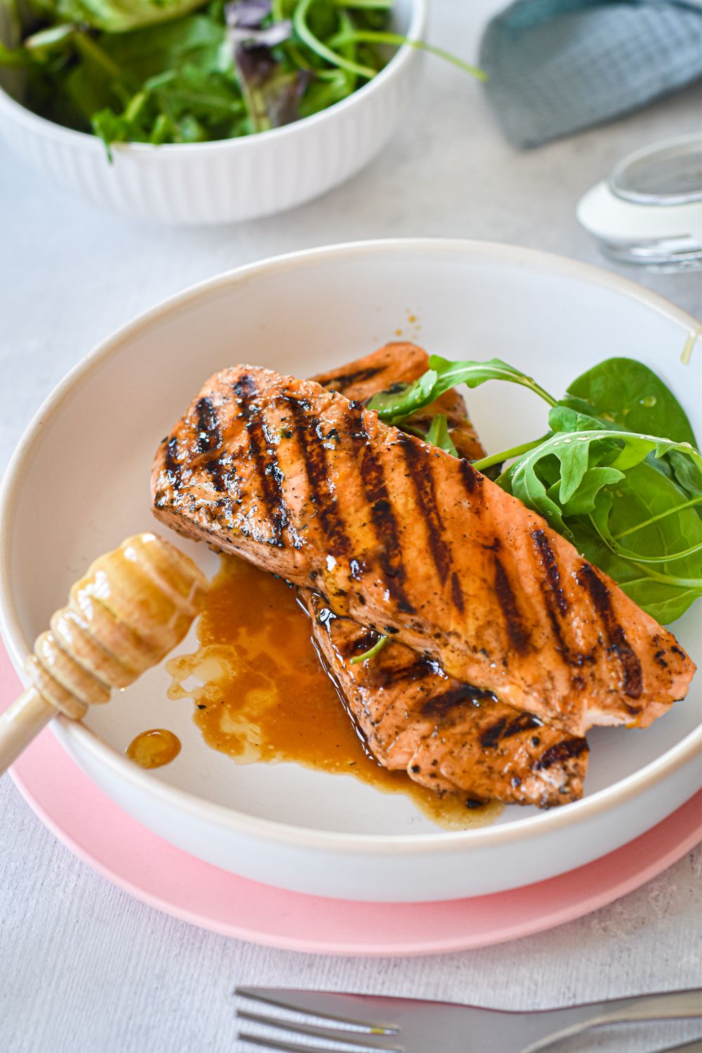 Salmon that has been grilled with honey and lime juice with a salad on the side.