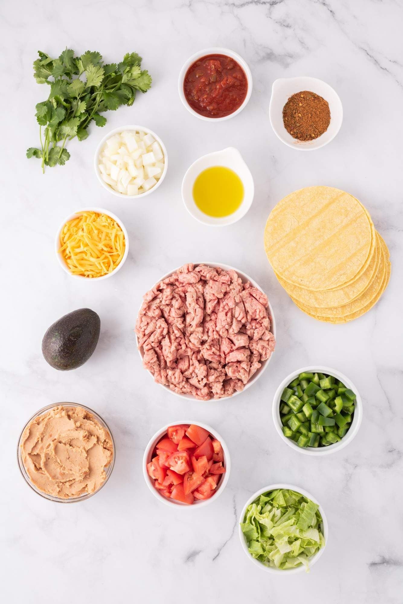 Ingredients for ground turkey tostadas including cilantro, salsa, taco seasoning, beans, cheese, and more.