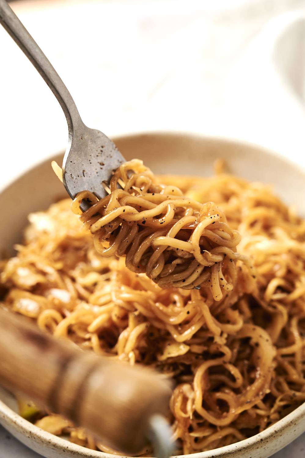Fork with healthy chow mein noodles and cabbage.