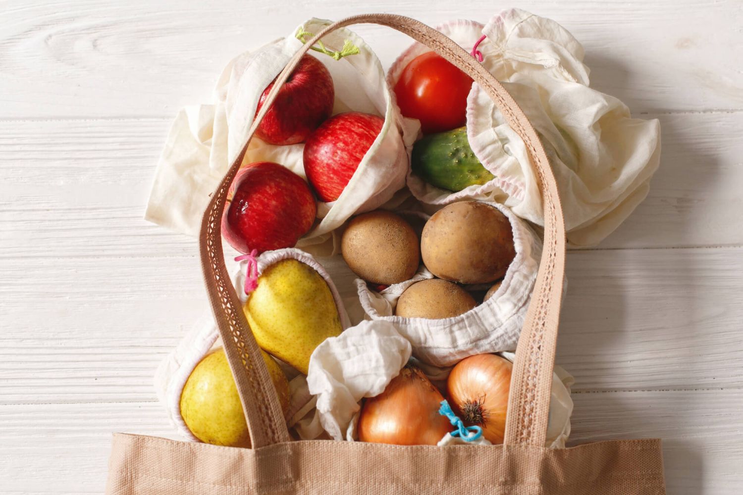 Healthy groceries in a bag on a white counter.