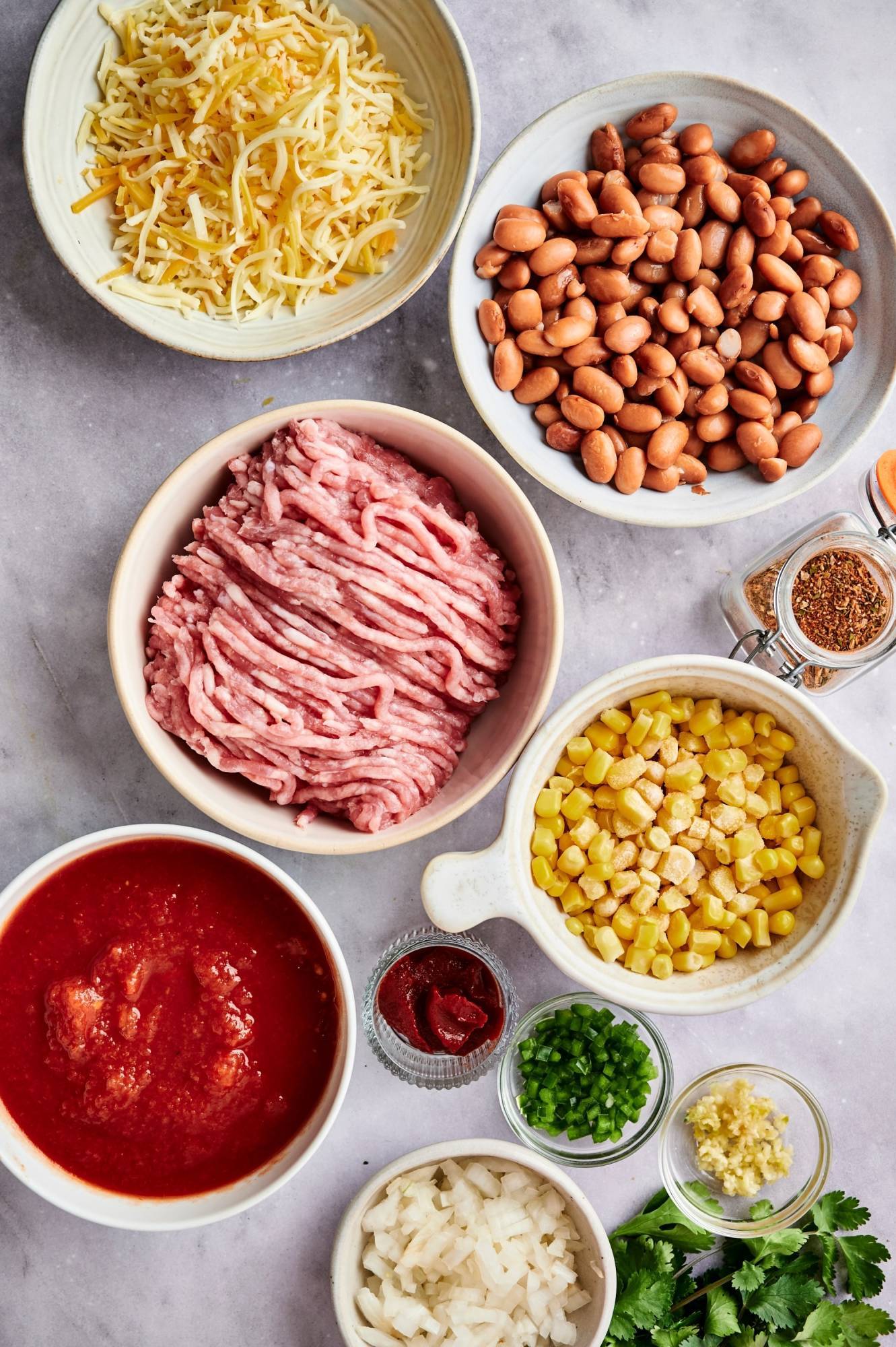 Ingredients for taco casserole including ground turkey, pinto beans, spices, cheese, taco seasoning, and salsa.
