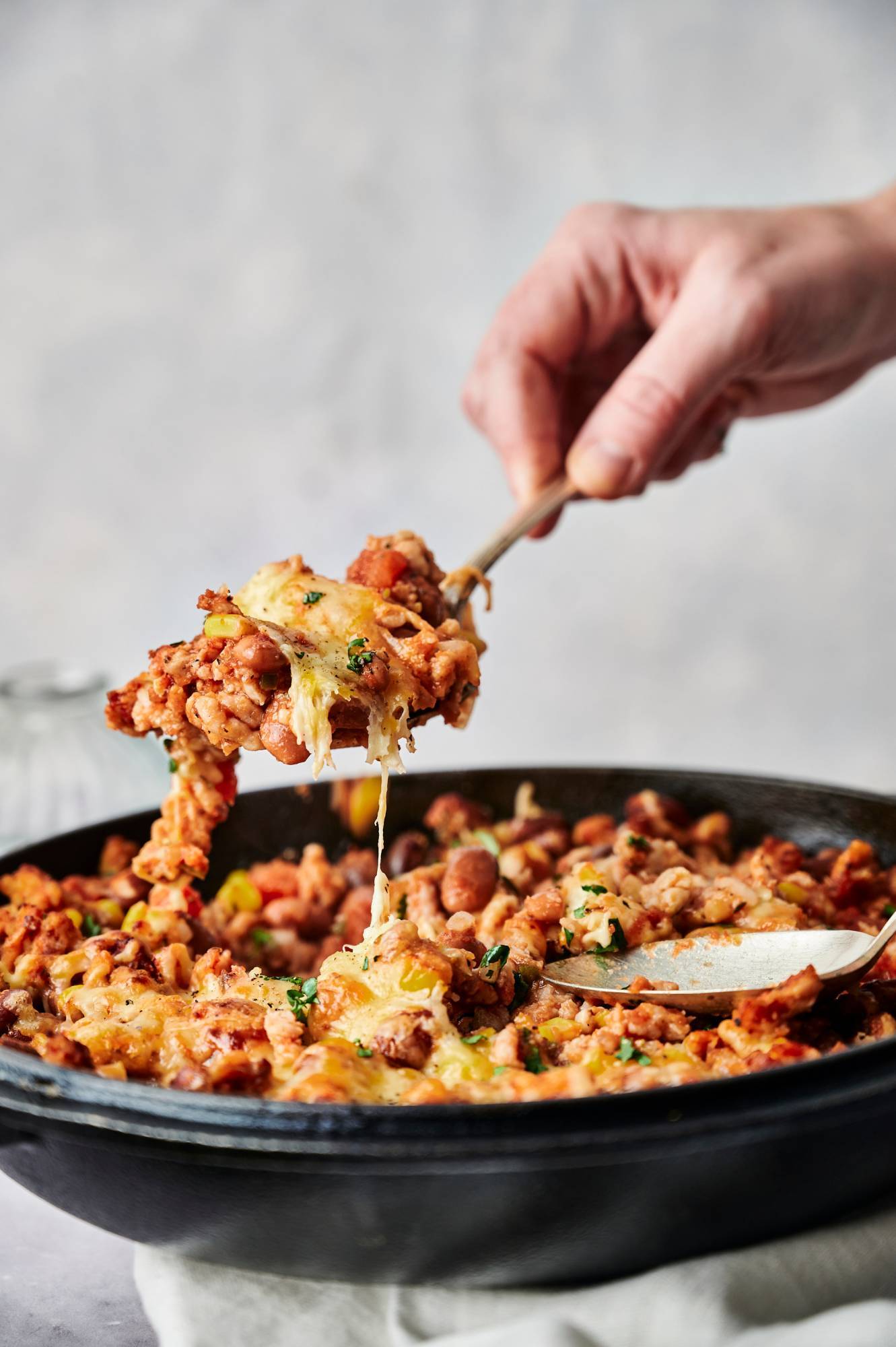 Healthy taco casserole with ground turkey and pinto beans being scooped up in a spoon.