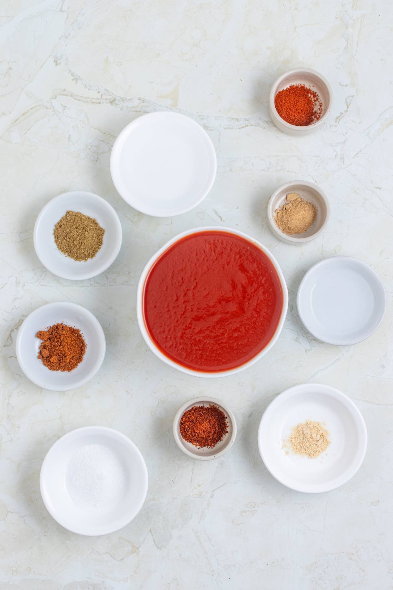 Ingredients for taco sauce including tomato sauce, vinegar, sugar, chili powder, garlic powder, onion powder, paprika, cumin, and cayenne pepper.