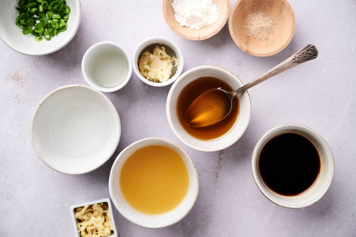 Ingredients for homemade teriyaki sauce including soy sauce, pineapple juice, garlic, ginger, rice vinegar, and green onions.