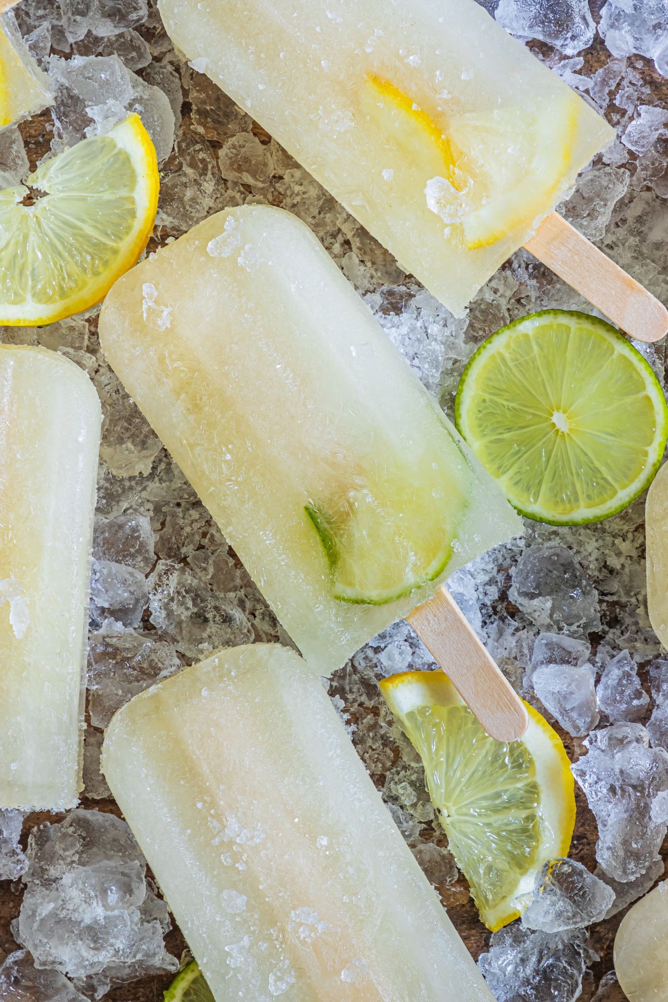 Popsicles made with lemon juice, lime juice, and honey on a tray with ice.