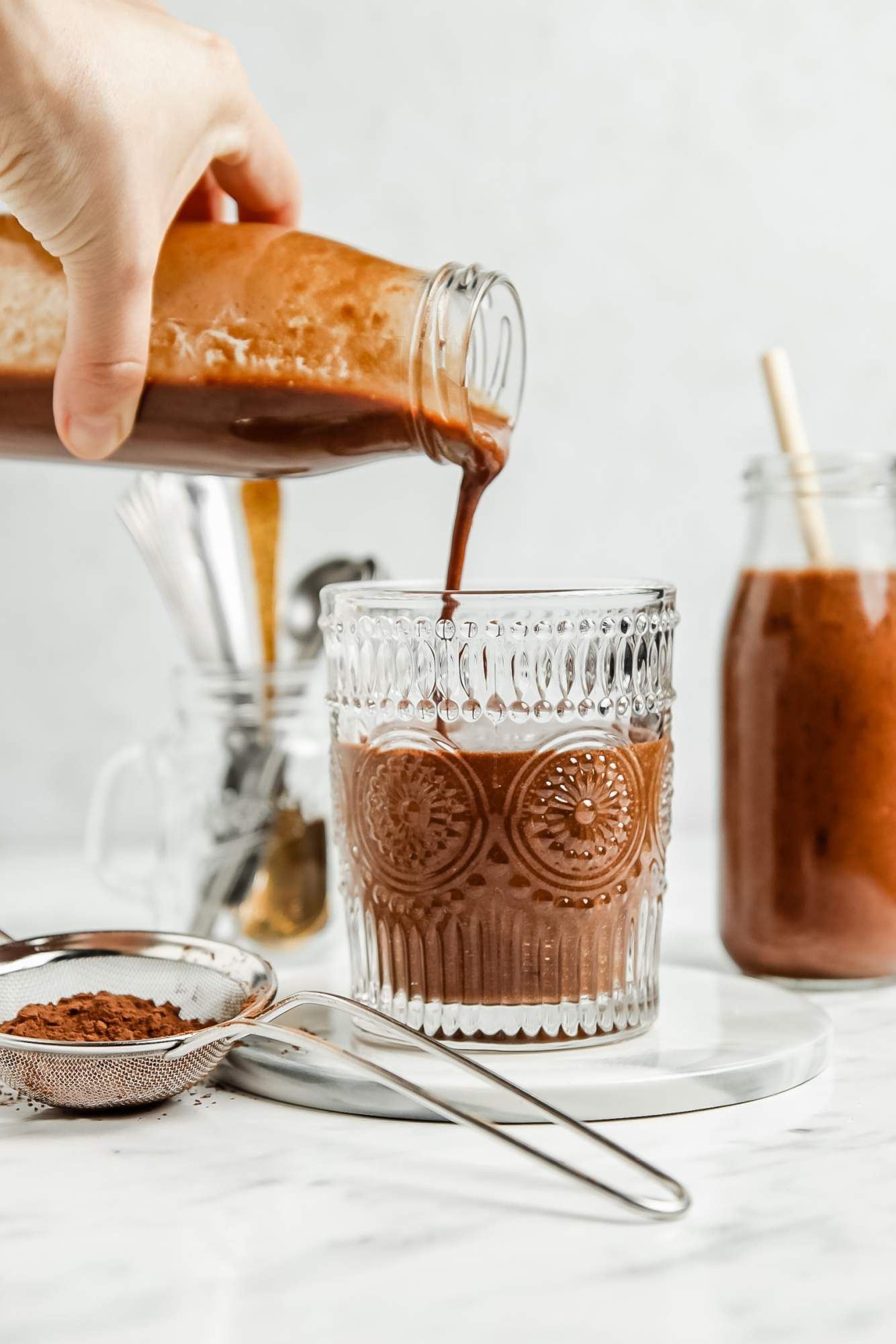 Mocha coffee smoothie with bananas and coffee being poured into a glass.
