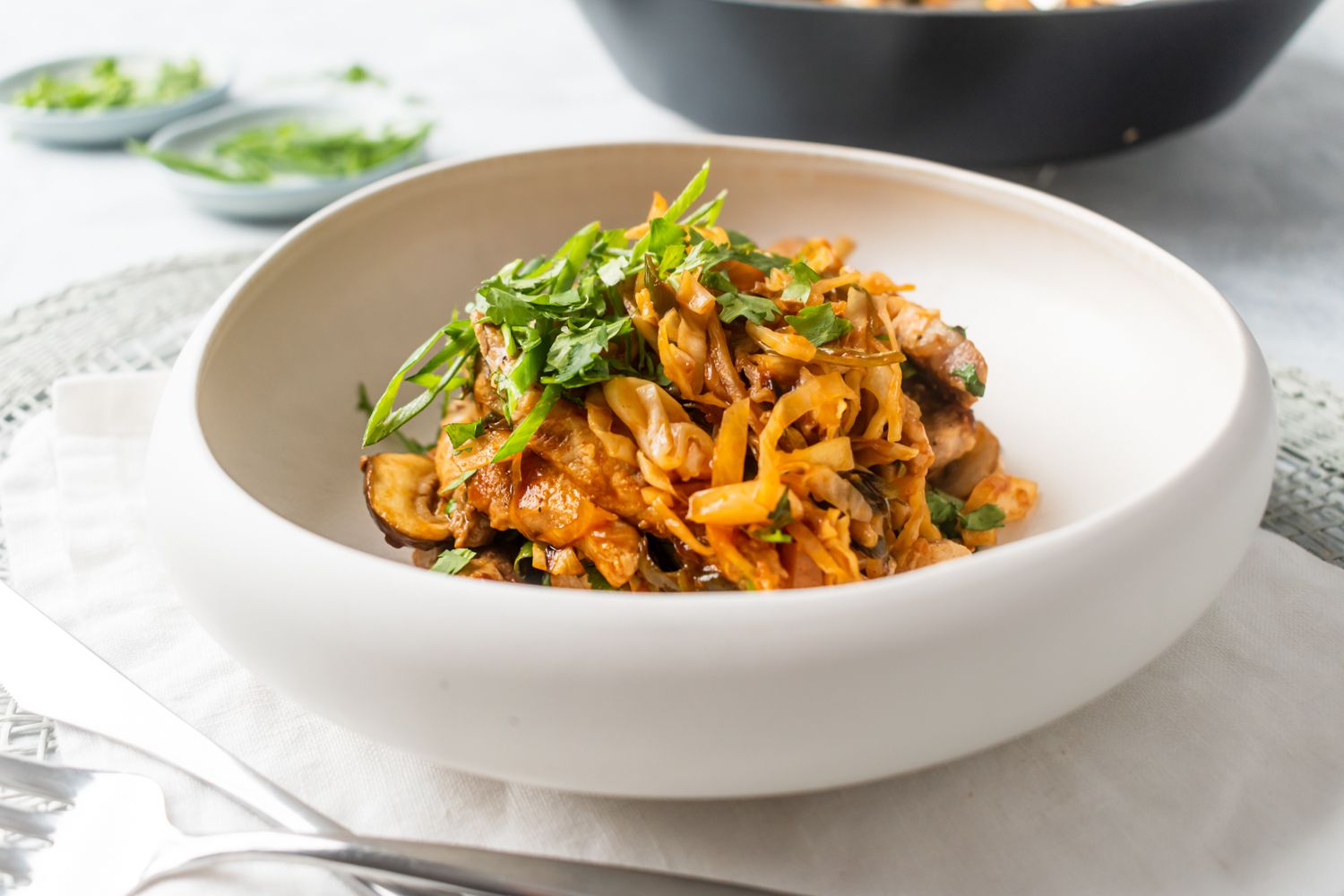 Pork stir fry with moo shu sauce, thinly sliced pork, mushrooms, cabbage, carrots, and fresh herbs.
