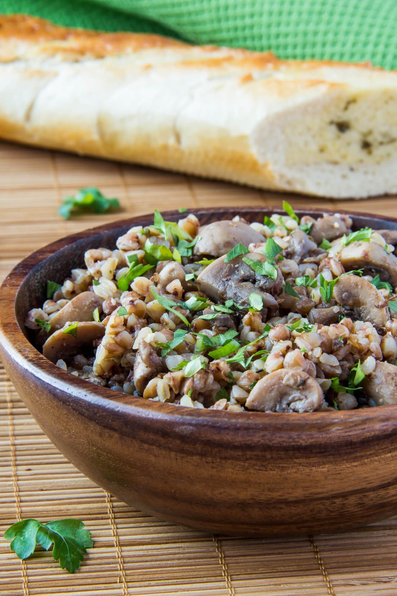 Mushroom barley bowls with tender mushrooms and barley in a bowl with garlic bread on the side.