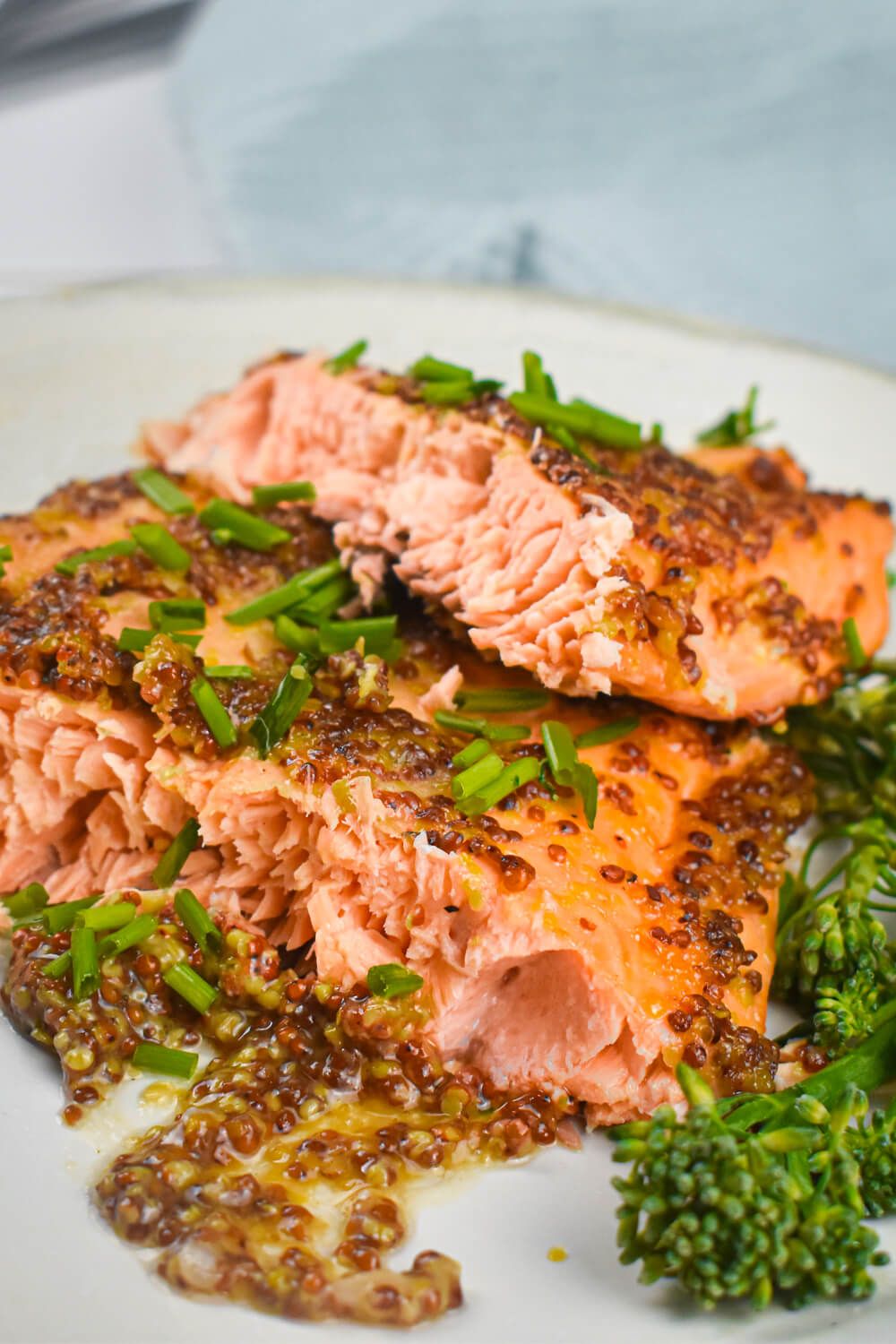 Maple Mustard Salmon  with honey mustard sauce on a plate with broccolini.