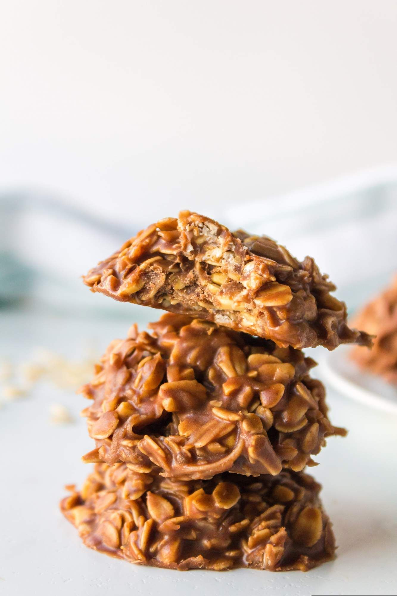 No bake oatmeal cookies with peanut butter and chocolate stacked on a plate.
