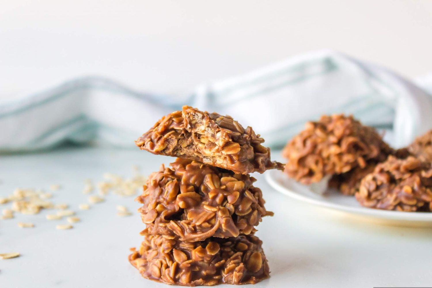No bake cookies made with oats, peanut butter, chocolate, and coconut oil in a small stack.