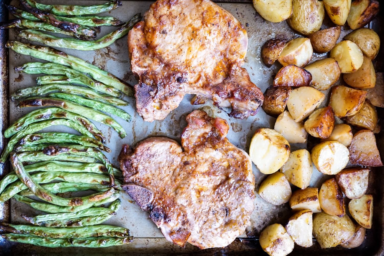 Sheet Pan Pork Chops, Potatoes, and Green Beans caramelized and ready to eat.
