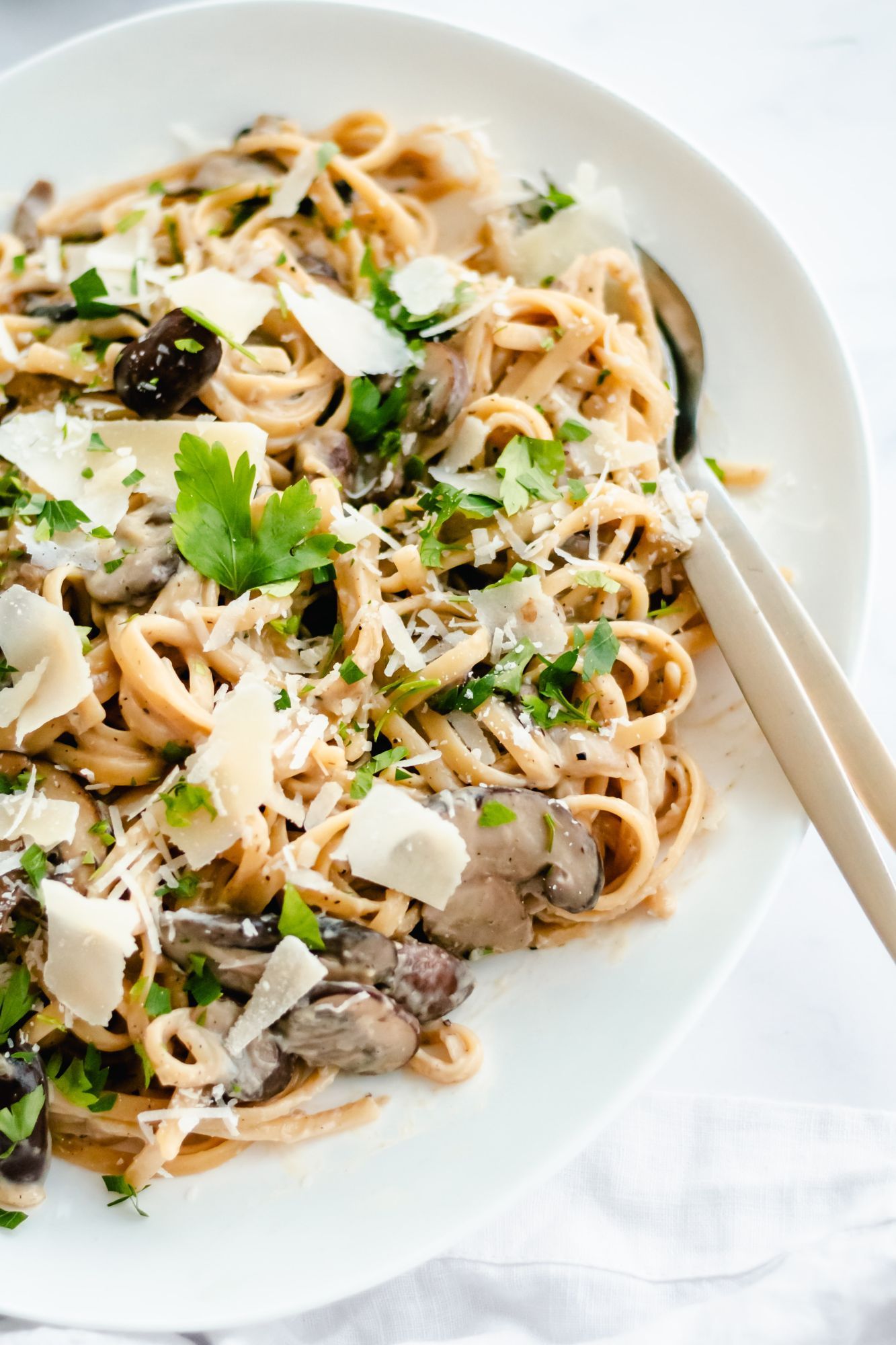 Mushroom pasta with linguini, creamy sauce, and mushrooms served with Parmesan cheese and parsley.