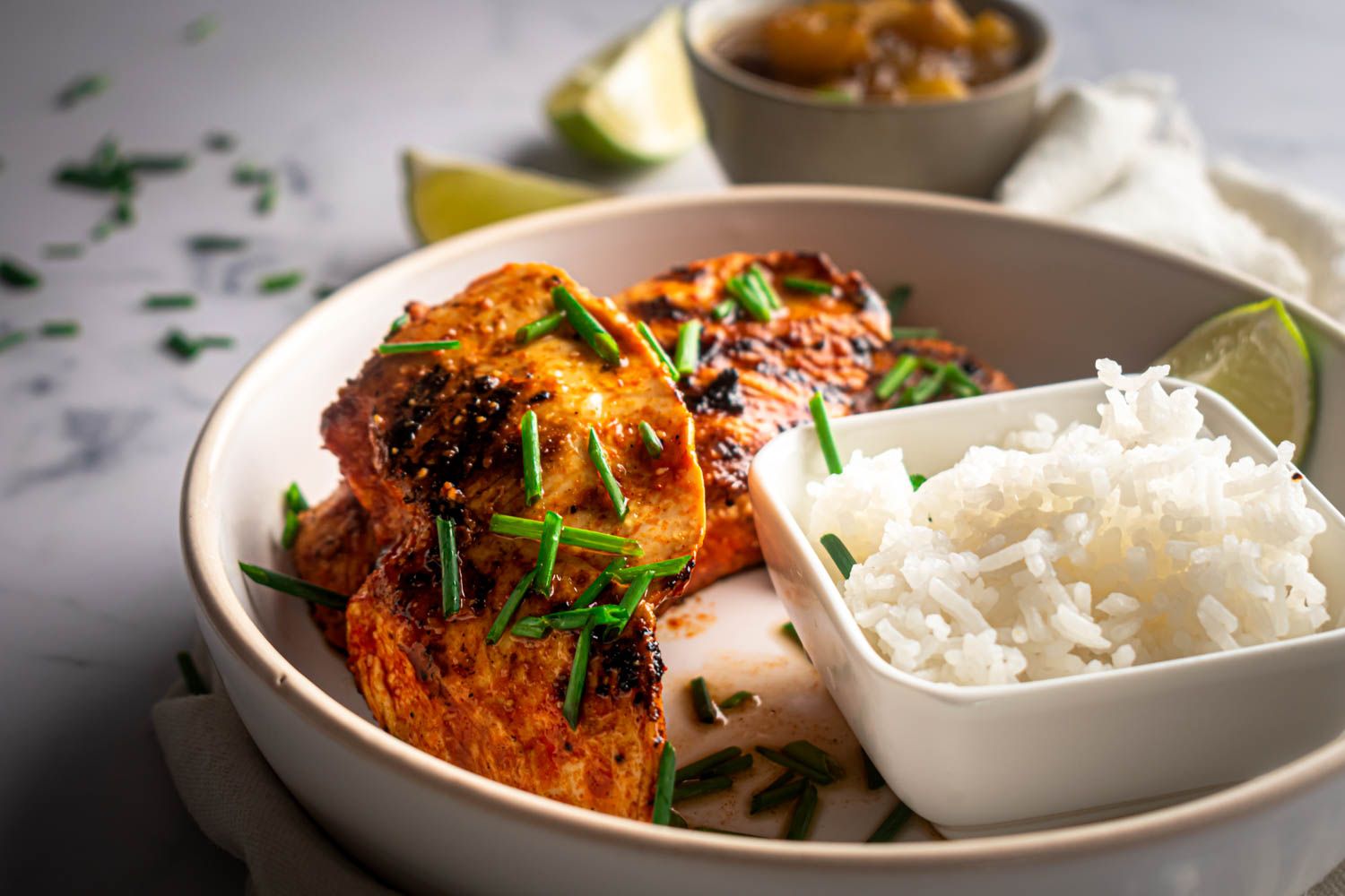 Chicken breast marinated with paprika, lime juice, and garlic and then cooked until browned in a bowl with rice.